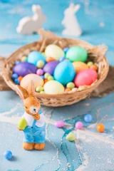 Cute decorative Easter bunny and colorful easter eggs on a blue background © Daniela Baumann