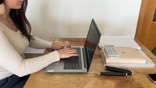 Travelling lateral de joven profesional tecleando en su laptop