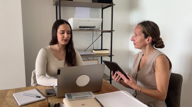 Joven profesional trabajando con compa&ntilde;era de su equipo