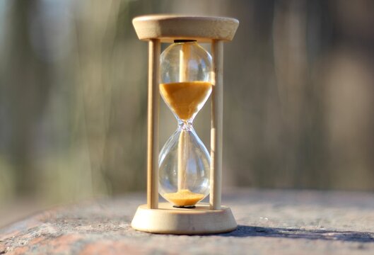 Hourglass on the stone surface concept of passing time hurry up live bein time 