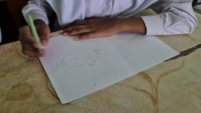 Close-up of Student Hands Drawing Character Sketches on Sketchbook and Paper