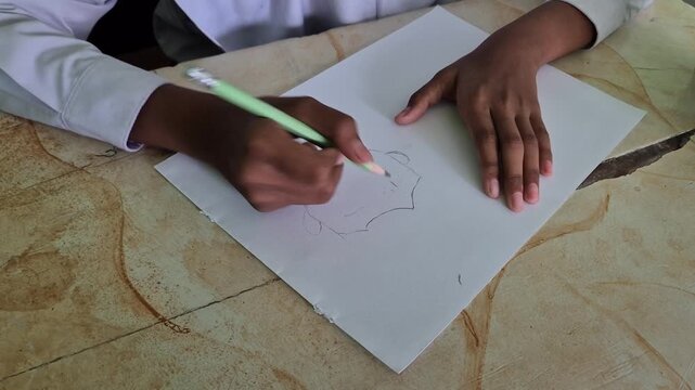 Close-up of Student Hands Eraser and Drawing Character Sketches on Sketchbook and Paper