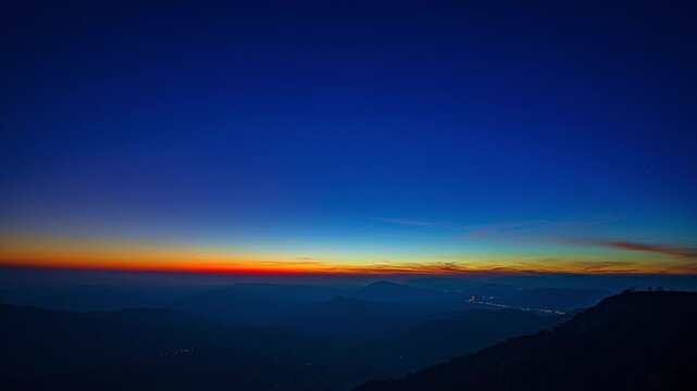 Gentle rays rise above the distant ridges, illuminating the wilderness with a warm morning shimmer. This time lapse showcases the peaceful beauty of a mountain sunrise spreading across the horizon.
