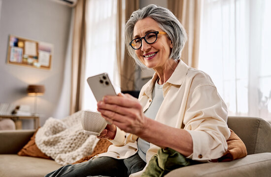 Portrait of senior woman with smartphone with smile, texting or communication on couch in home for relax.