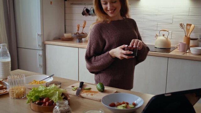 Woman takes salad ingridient dancing as slices cucumber for lunch