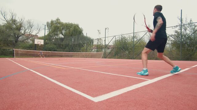 Tennis practice on a pink clay court in the afternoon with a focus on forehand techniques