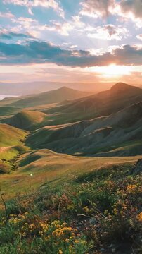 Stunning sunset over rolling green hills and vast ocean, tranquil nature scene with vibrant sky.