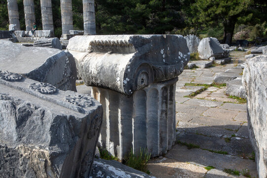 Ruined columns of Athena Temple with acropolis cliff in ancient city Priene Turkey