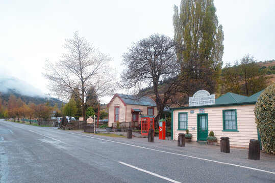 Cardrona, New Zealand: A quiet mountain road lined with historic wooden buildings and autumn trees near the Cardrona Hotel.