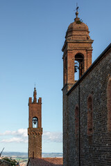 Fototapeta premium Bell towers rising above Tuscany landscape in Montalcino, Italy.