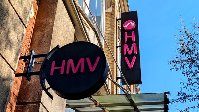 Leicester, England, UK - 21 March 2026: HMV store signage, pink retail shop logo on black background, music and entertainment retailer exterior, famous brand identity, urban record store facade