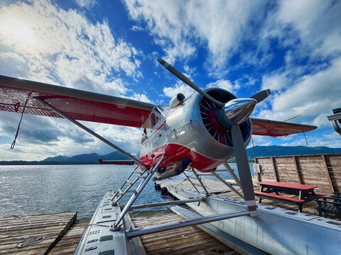 Red and White Propeller Plane Docked at Rustic Wooden Jetty