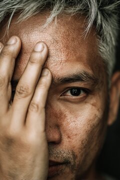 portrait of a handsome filipino man with grey hair covering his face