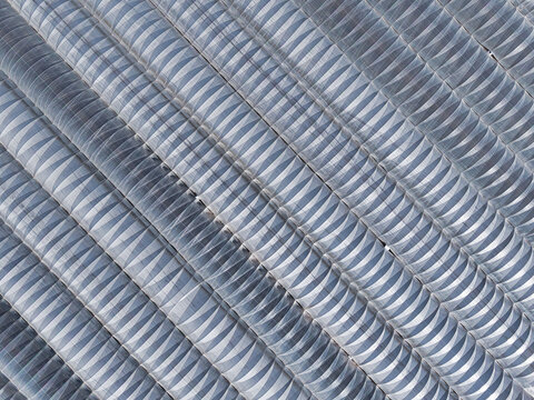 Aerial view of corrugated metal roofing, a textured landscape of repeating curves and shadows creating an abstract architectural pattern, Stafford, England, United Kingdom.