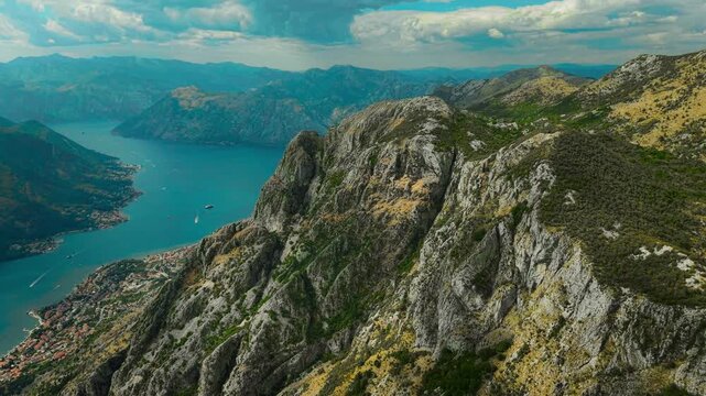 Aerial view of Kotor Bay's turquoise waters meeting rugged mountains, creating a stunning contrast of blues and greens, Spiljari, Cetinje Municipality, Montenegro.