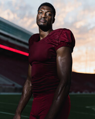 Determined Black male athlete in football uniform on sports field