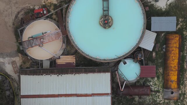 Aerial view of tanks and industrial buildings in a landscape, showcasing a blend of textures and colors, Arsoli, Lazio, Italy.