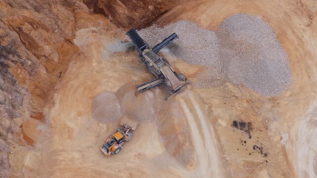 Aerial view of heavy machinery contrasting against the raw earth and piles of extracted materials, showcasing textures and tones, Arsoli, Lazio, Italy.