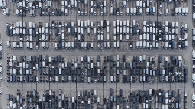 Aerial view of neatly arranged rows of cars, creating a textured pattern with alternating light and dark tones, Atessa, Abruzzo, Italy.