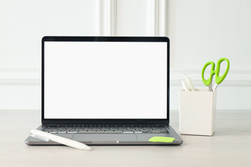 Fototapeta premium Stylish workplace. Laptop with blank screen and stationery on white wooden table
