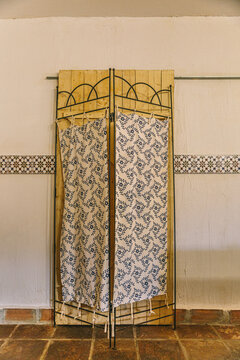 Ornate folding screen with patterned fabric and wooden panels