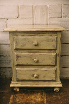 Weathered vintage wooden nightstand with rustic drawers
