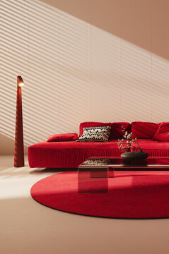Modern interior design of living room with vibrant red sofa and empty white wall background. 3D Rendering, 3D Illustration