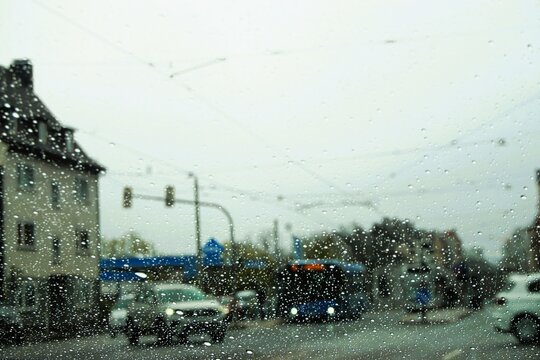 Innenstadtpanorama mit Stra&szlig;enverkehr von Bus, Bahn und Autos in Gro&szlig;stadt bei Schneeregen, Sturm und K&auml;lte am Nachmittag im Winter