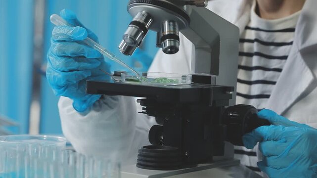 Medical or scientific researcher or man doctor looking at a test tube of clear solution in a laboratory