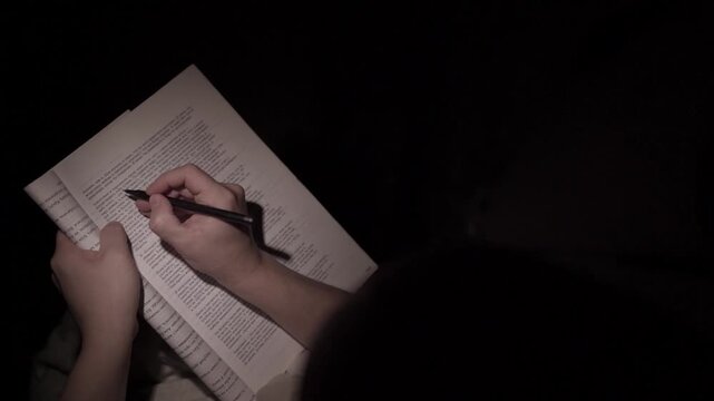 Man Reading and Making Notes at Night