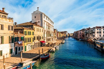 Obraz premium city of Venice with beautiful old buildings near embarkment of a canal wirh boats and water and beautiful cloudy sky on background