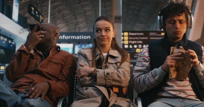 Highly Sensitive Passenger Sits Amidst Chaos of Terminal, Showing Signs Sensory Processing Struggle. Woman Remains Still and Focused, Regulating Emotions Against Loud Environment. Sensory Sensitivity.