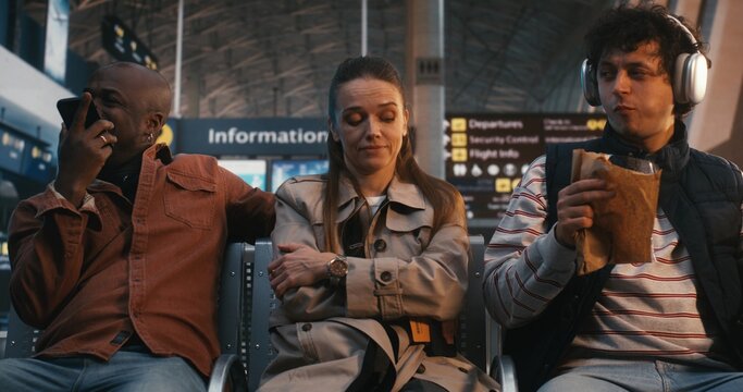 Highly Sensitive Passenger Sits Amidst Chaos of Terminal, Showing Signs Sensory Processing Struggle. Woman Remains Still and Focused, Regulating Emotions Against Loud Environment. Sensory Sensitivity.