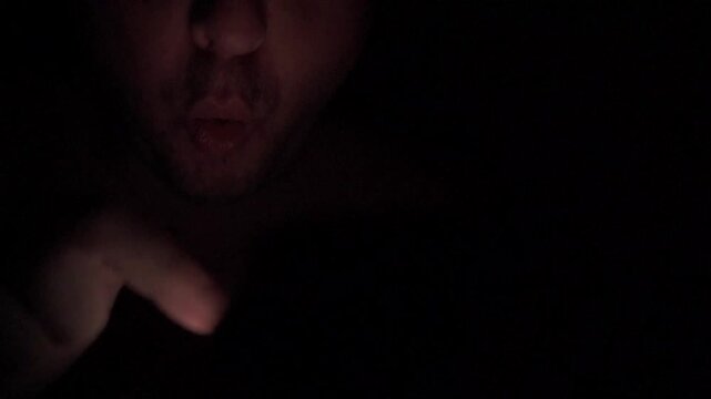 Man Scrolling Social Media on Smartphone at Night