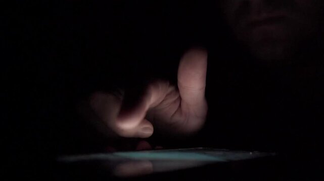 Man Scrolling Social Media on Smartphone at Night