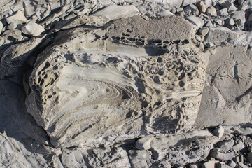 Naklejka premium Close-up of eroded rock formations with natural textures and patterns in Ngapali, Rakhine State, Myanmar. Geological coastal detail shaped by erosion in tropical Southeast Asia.