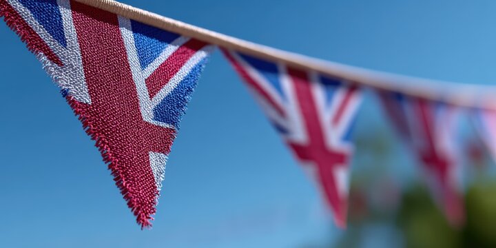 patriotic website banner, a vivid shot of hand-stitched union jack bunting against a clear blue sky, with the closest flag in sharp focus, perfect for a website header