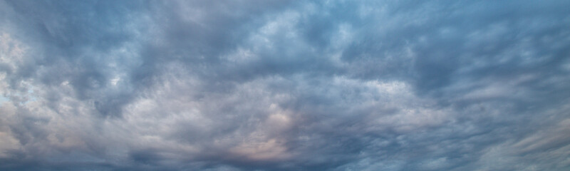 Obraz premium Soft clouds drift across a serene blue sky