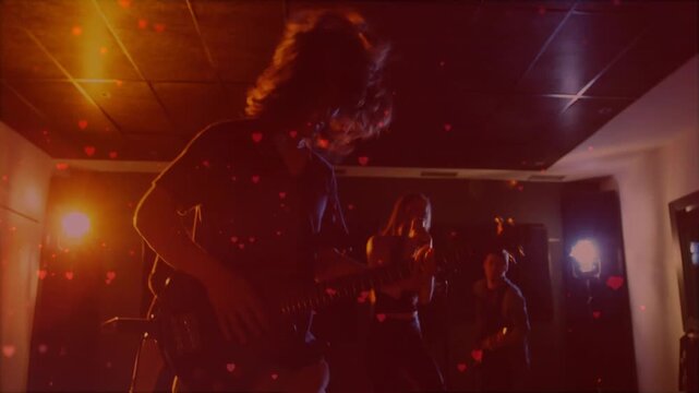 Singer stepping to mic starting band practice, guitarist riffing and headbanging, hearts drifting