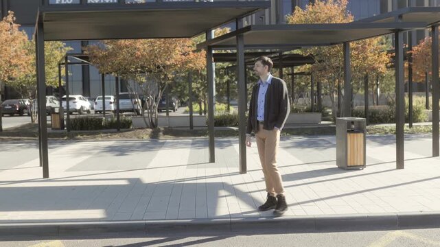 Wide shot of one man pacing and waiting in a sunny autumn park, surreal style.