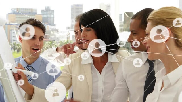 Lead writing flipchart in business meeting, team annotating as network graphic growing denser