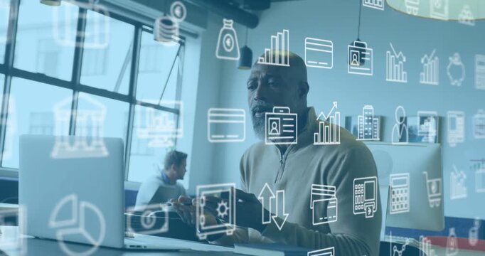 Starting looking at monitor, mature man in beige zip explaining finance in office, icons drifting