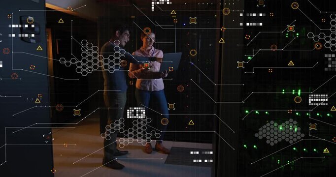 Female tech scrolling laptop, activating HUD while male tech pointing at datacenter racks for debug