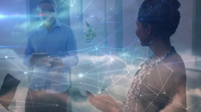 Vertical video: Looking down woman in patterned blouse tapping smartphone in office, cloud overlay