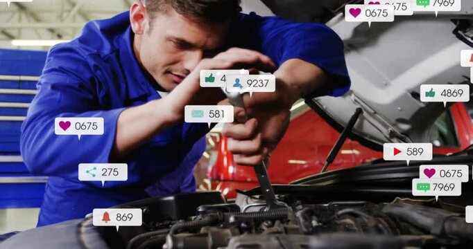 Turning tech in blue coveralls tightening bolt with combo wrench in shop, with social alerts rising