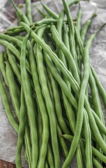 Obraz premium A Large Bunch of Long Green Snap Beans Placed on a Crumpled Paper