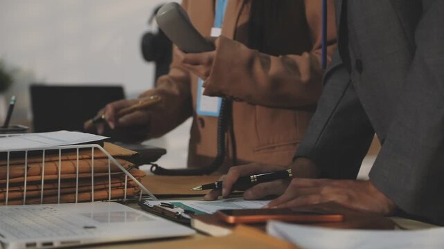 Close up of businessman or accountant hand holding pen working on calculator to calculate business data, accountancy document and laptop computer at office, business concept