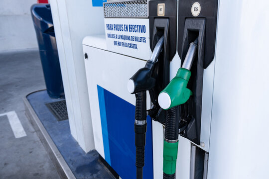 Fuel pump with two nozzles at gas station, close-up detail.