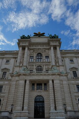 Fototapeta premium Grand ornate European classical building facade with columns and arches against blue sky