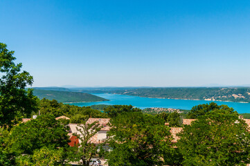 Fototapeta premium Overlooking lac de Sainte-Croix, a beautiful mountain lake in the French provence, from the town of Aiguines.